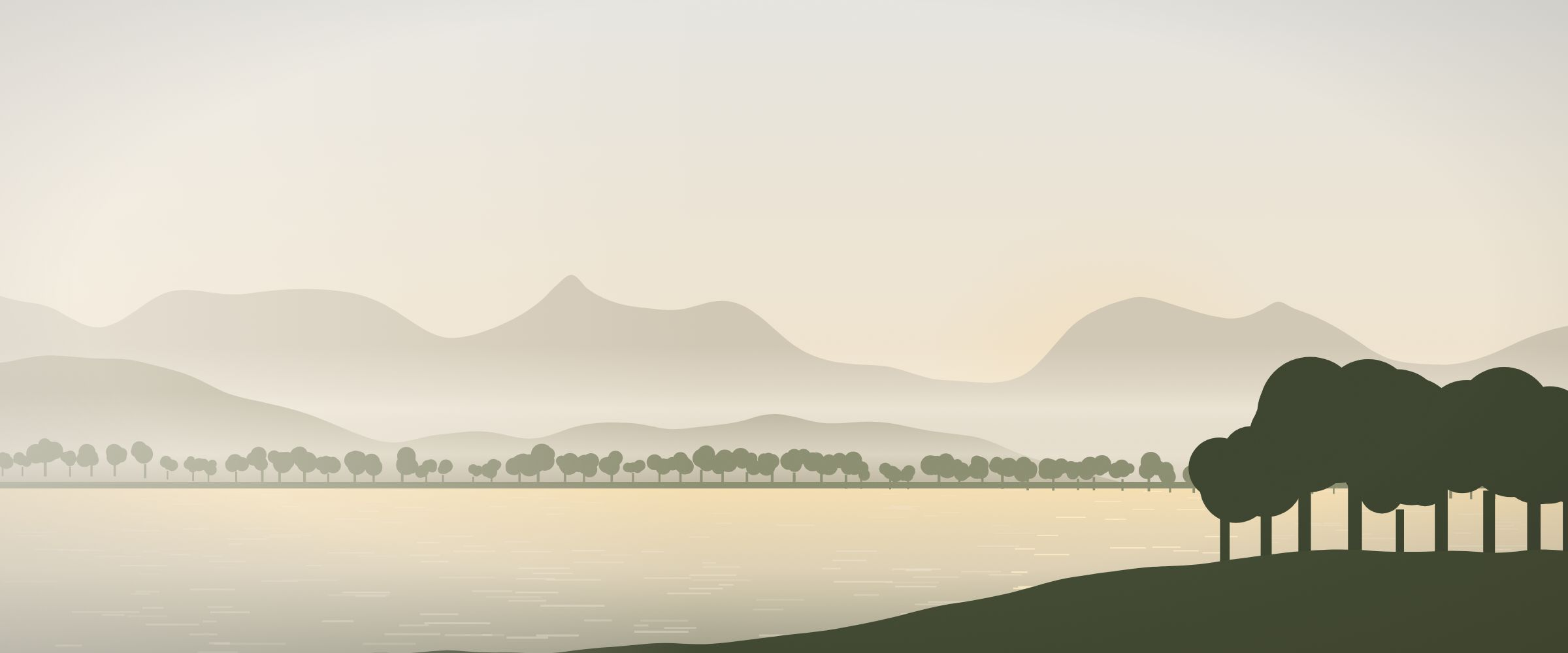 A calm lake below misty hills at first light